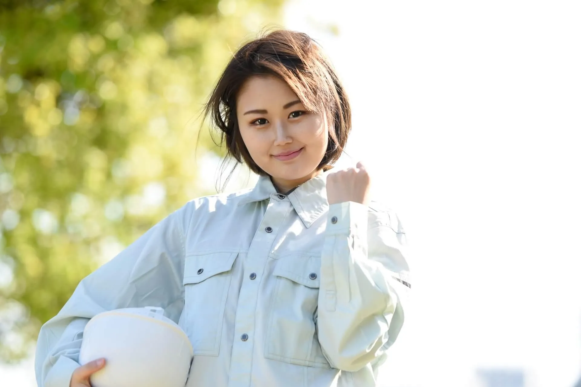 ポーズをとる作業着を着た女性