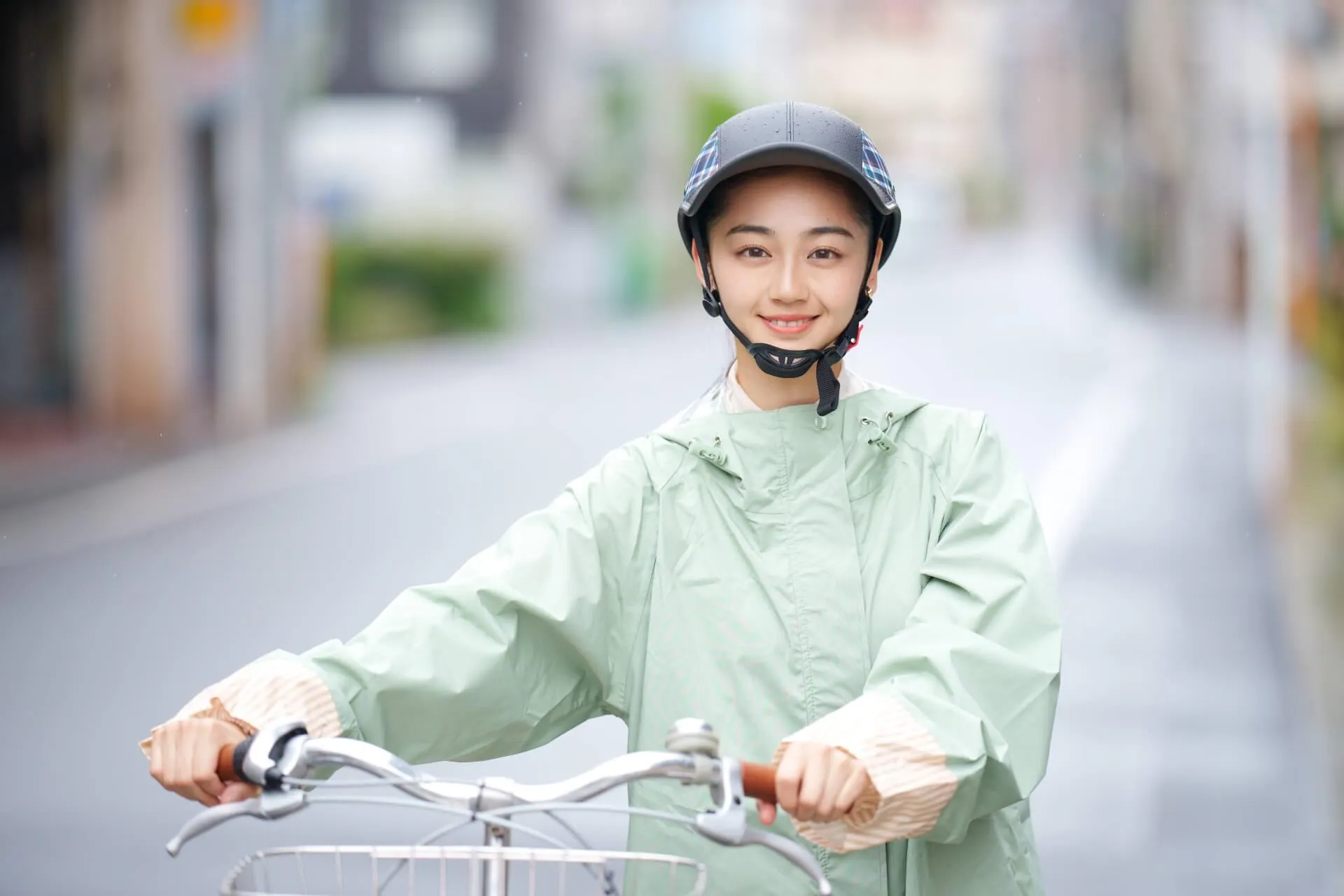 黄緑色のレインウェアを着た女性