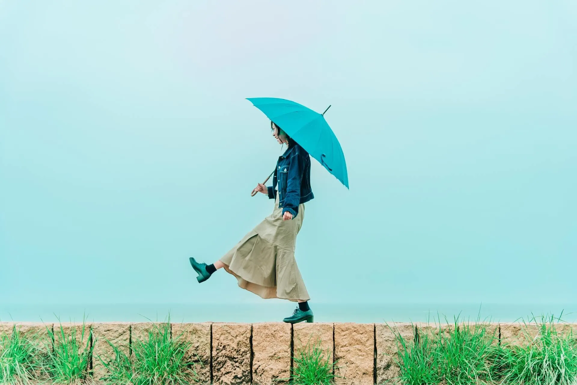 青い傘をさしている女性