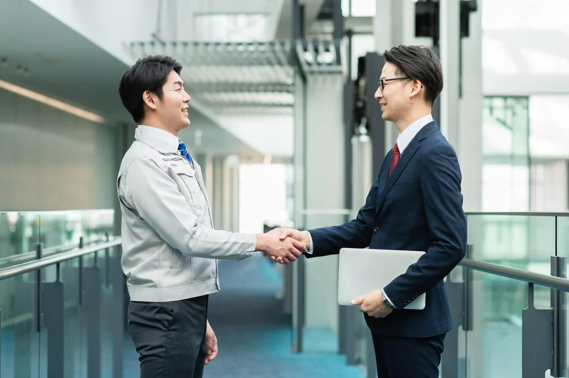 握手をする会社員ら
