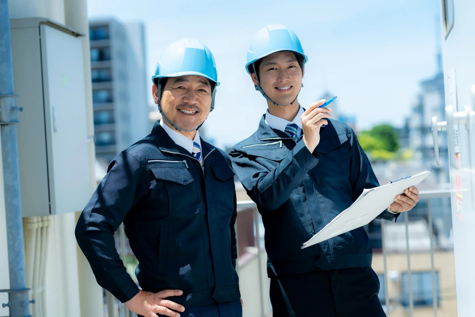 青いヘルメットを被った現場監督ら