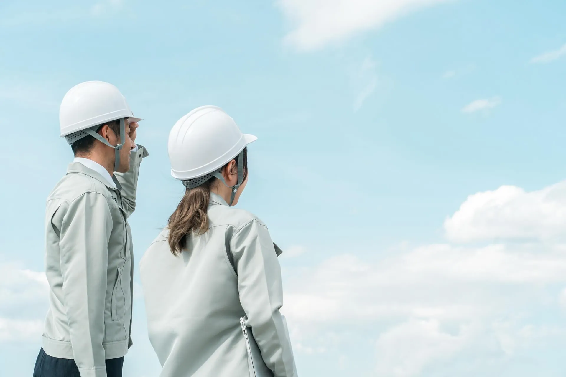 ヘルメットを被っている建設会社の男女